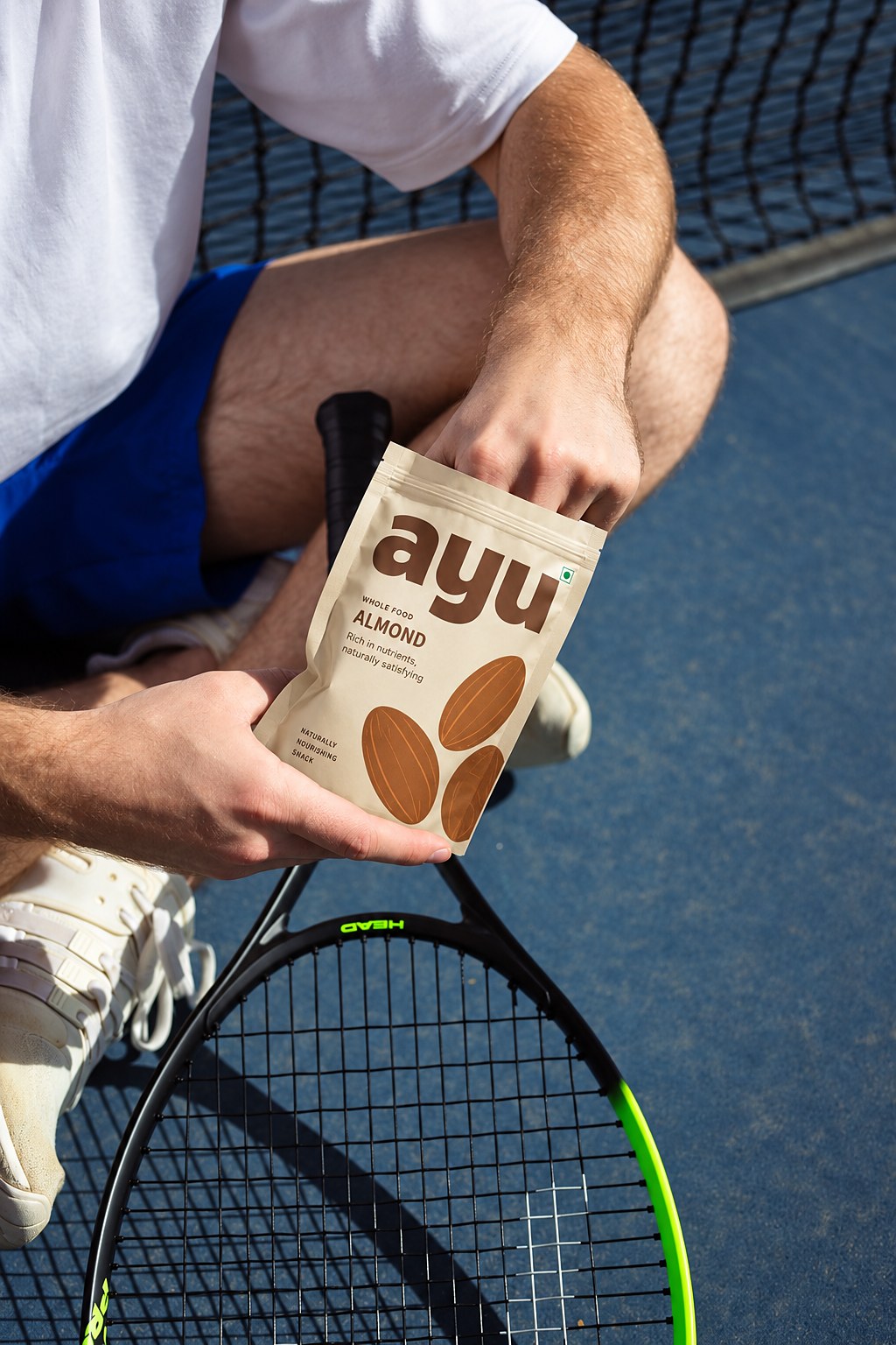 A tennis player reaching into a pack of ayu whole food almonds